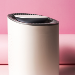 a humidifier sitting in front of a pink wall